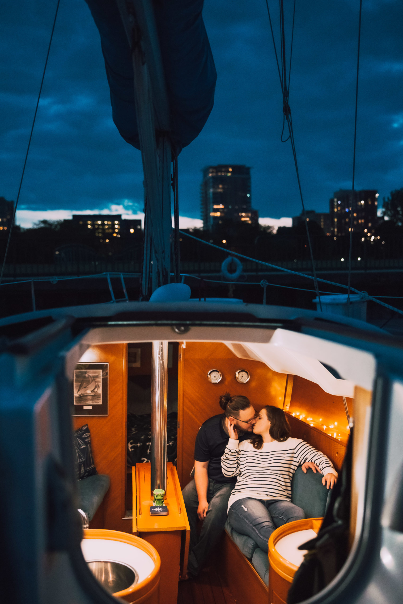 Man and woman kiss inside boat
