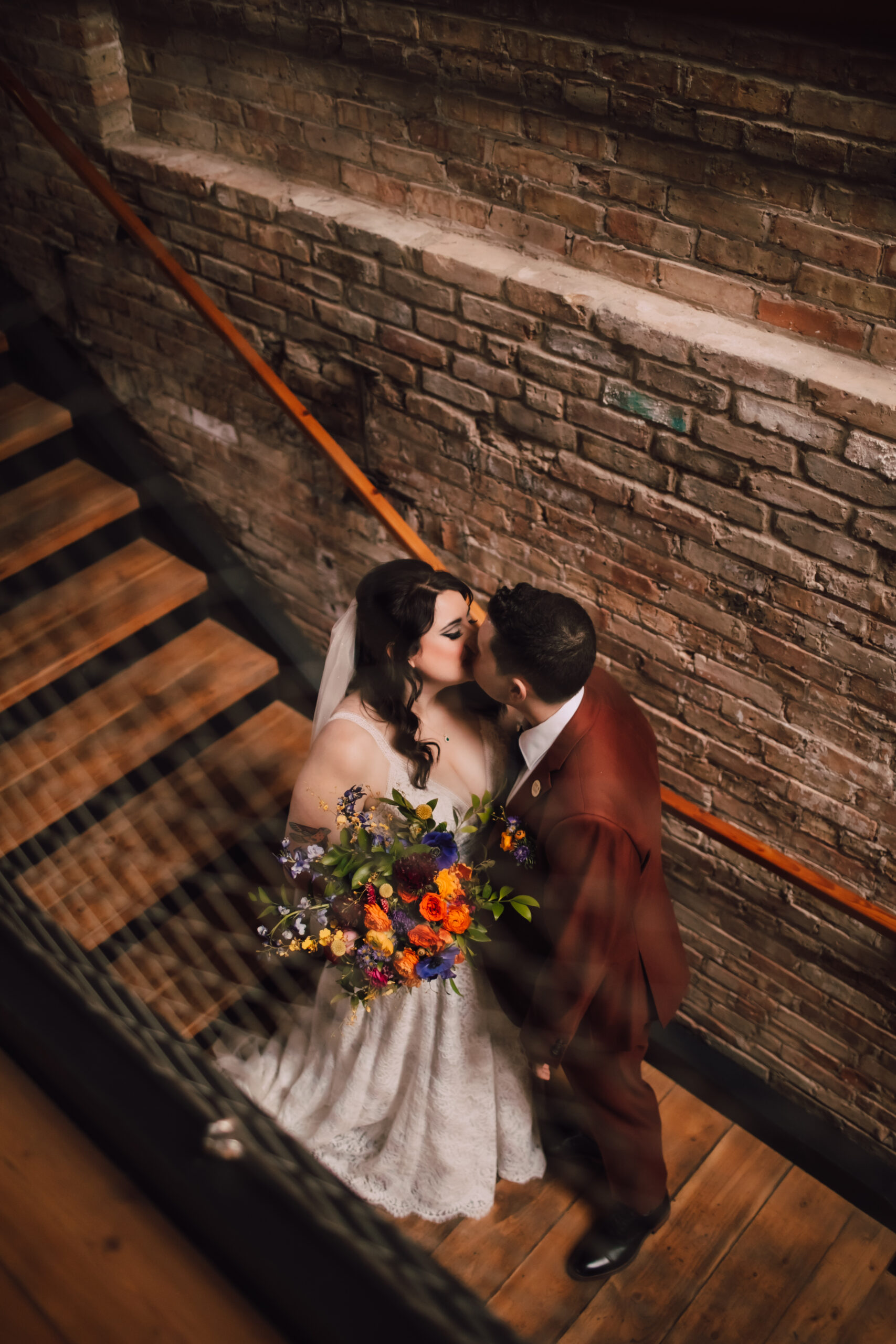 Bride and groom kiss on a staircase